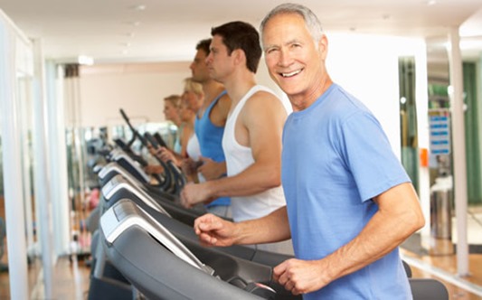 Senior Man On Running Machine In Gym