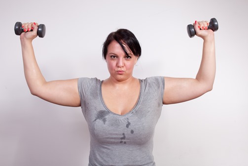 Size plus woman sweating during weight training